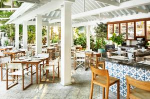 a restaurant with tables and chairs and a bar at Parrot Key Hotel & Villas in Key West
