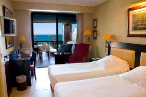 a hotel room with two beds and a view of the ocean at Gran Hotel Guadalpín Banus in Marbella