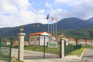 a fence with flags in front of a house at Pinerose Resort in Bansko