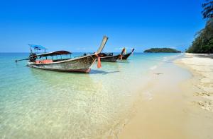two boats sitting on the shore of a beach at JR Place in Klong Muang Beach