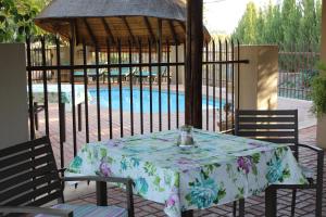 een tafel en stoelen voor het zwembad bij The Falls Guest House in Augrabies