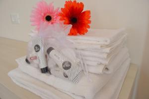 une pile de serviettes avec des fleurs au-dessus de celles-ci dans l'établissement Palazzo Liberty BnB, à Bologne
