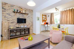 a living room with a tv and a brick wall at Villa La Vagabonda in Orasac
