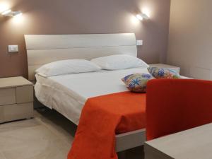 a bedroom with a white bed with a red table at Casa Bandiera in Siracusa