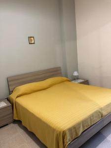 una camera con letto e copriletto giallo di Casa vacanze Il Ruscello a Modolo