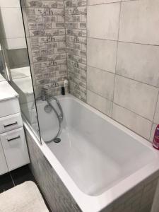 W łazience znajduje się biała wanna z prysznicem. w obiekcie Apartament Grochowy - Poznań Stare Miasto w Poznaniu
