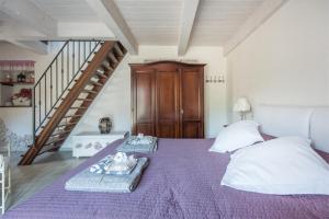 a bedroom with a purple bed and a staircase at Casa Francesca in Castiglione di Sicilia
