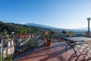 a balcony with a table and a view of the mountains at Casa Francesca in Castiglione di Sicilia