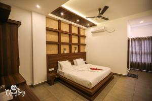 a bedroom with a bed and a ceiling fan at Hotel CloudBay in Kattappana