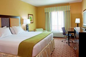 a hotel room with two beds and a desk at Holiday Inn Express Hotel & Suites Chaffee - Jacksonville West, an IHG Hotel in Jacksonville