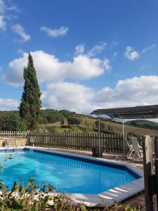 une piscine bleue avec une clôture en bois dans l'établissement Agriturismo Mezzo Poggio, à Suvereto