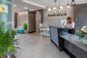 Eine Frau, die an einem Tresen in einem Büro in Anarmaarma steht. in der Unterkunft Hotel Amaraigua – All Inclusive – Adults Only in Malgrat de Mar