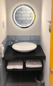 La salle de bains est pourvue d'un lavabo et d'un miroir. dans l'établissement ibis Styles Manchester Portland, à Manchester