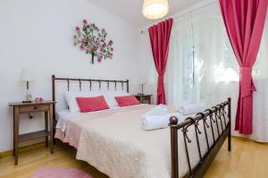 a bedroom with a large bed with pink pillows at Villa La Vagabonda in Orasac