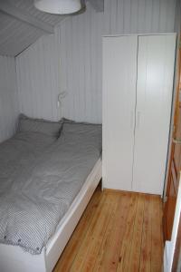 グリュックスブルクにあるBullerby _ Meer _ Ferienhaus Lottaのベッドルーム1室(ベッド1台、白いキャビネット付)