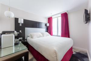 um quarto de hotel com uma cama e uma secretária em Hôtel 15 Montparnasse em Paris