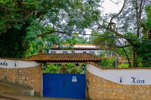 um portão azul numa parede de pedra com uma porta azul em Pousada Xica da Silva em Tiradentes