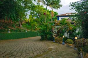 a garden with plants and a fence and a house at Pousada Xica da Silva in Tiradentes