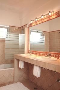 Un baño con dos lavabos y un espejo grande. en Casa Bela Moura, Boutique Hotel & Wine, en Porches