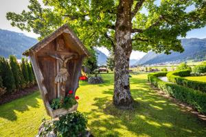 a wooden box sitting in the grass next to a tree at Michis Aparthotel in Flachau