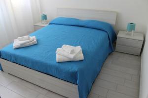 a bedroom with a blue bed with towels on it at A casa di Marta in Bari