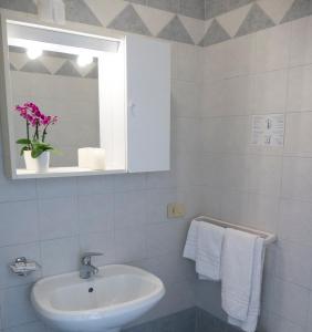 bagno con lavandino, specchio e asciugamani di Hotel Casa Mia a Lido di Jesolo