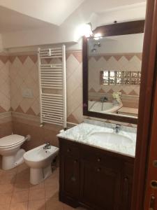 bagno con lavandino, servizi igienici e specchio di Dulcis Home Montemario a Roma