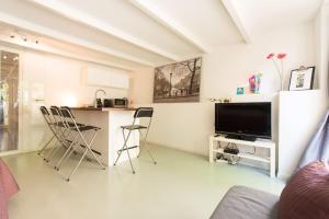 uma sala de estar com uma cozinha e uma mesa com cadeiras em Quiet apartment for 4 at park in center em Amsterdã
