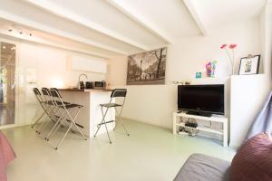 a living room with a kitchen and a table with chairs at Quiet apartment for 4 at park in center in Amsterdam