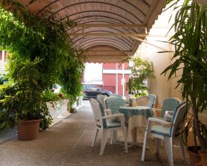 un patio con mesa, sillas y plantas en Hotel Casa Mia, en Lido di Jesolo