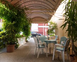 a patio with a table and chairs and plants at Hotel Casa Mia in Lido di Jesolo