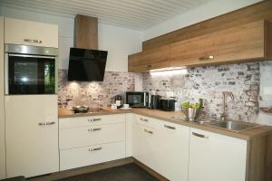 a kitchen with white cabinets and a sink at Ferienwohnung MeinFriKo in Friedrichskoog-Spitze