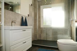 a bathroom with a sink and a toilet and a window at Ferienwohnung MeinFriKo in Friedrichskoog-Spitze