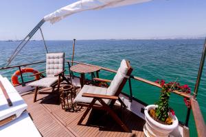 a boat with chairs and a table on the deck at Mulubinba SeaHouse in Olhão
