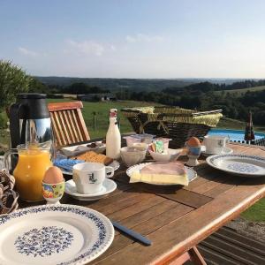 uma mesa de madeira com comida e bebidas em Gite Clara em Bassignac-le-Haut