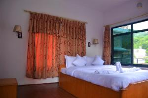 um quarto com 2 camas e uma janela em Pokhara Star Inn Pvt Ltd em Pokhara