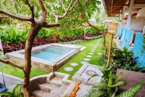 a backyard with a swimming pool and a tree at Balangan Inn Surf Homestay in Jimbaran