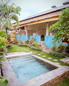 a swimming pool in the yard of a house at Balangan Inn Surf Homestay in Jimbaran