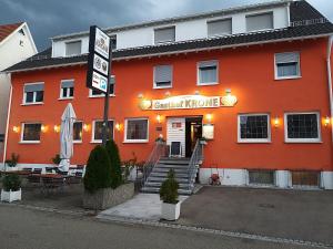 um edifício laranja com um cartaz que diz instituto de banquetes em Gasthof Krone em Adelberg
