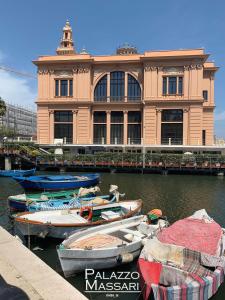 un bâtiment avec des bateaux dans l'eau devant lui dans l'établissement Palazzo Massari Bari, à Bari