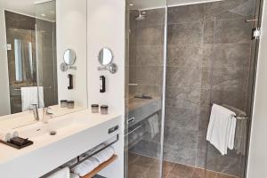 un bagno con doccia e lavandino di Steigenberger Alsik – Hotel & Spa a Sønderborg Altre 14 foto