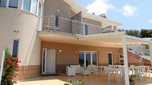 een huis met een balkon en witte tafels en stoelen bij Stella Marina Agropoli in Agropoli