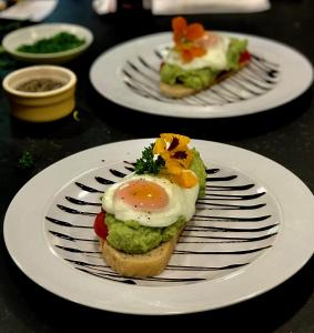 a plate with an egg on top of a sandwich at Mackay's Rooms in Durness