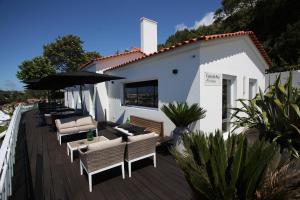a deck with chairs and umbrellas on a house at Quinta da Abelheira in Ponta Delgada