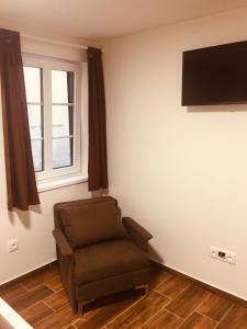 a living room with a chair and a flat screen tv at Penzion Šedivý in Strachotín