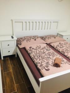 - une chambre avec un lit blanc et une couette rose dans l'établissement Penzion Šedivý, à Strachotín