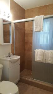 Coral Key Inn في فورت لاودردال: حمام مع دش مع مرحاض ومغسلة