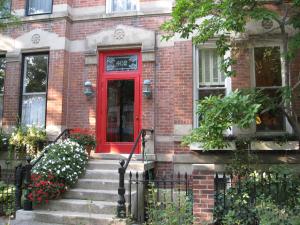 una porta rossa su una casa di mattoni con scale di webster house a Chicago