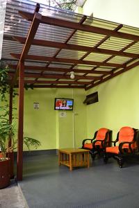 una camera con due sedie, un tavolo e una TV di Hotel Posada del Centro a Guatemala