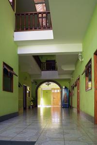 pasillo vacío con paredes verdes y balcón en Hotel Posada del Centro en Guatemala